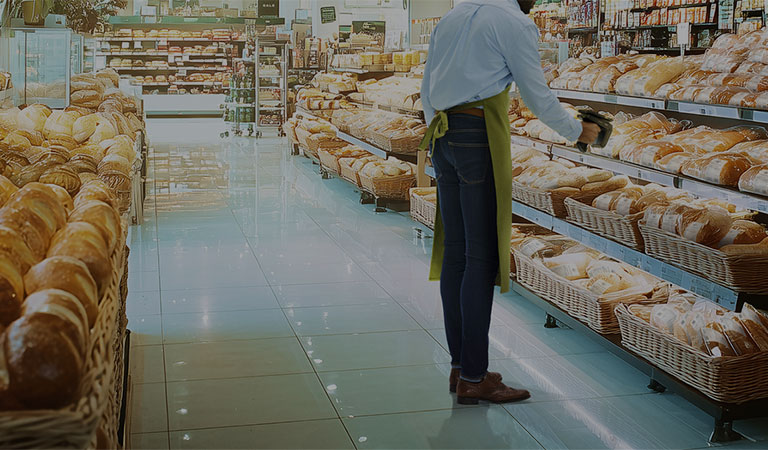 A worker scanning bread at a grocery store